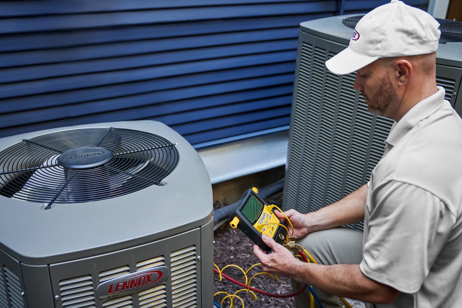 AC and Heating Repair Technician HVAC technician checking an outdoor air conditioning unit during a repair visit