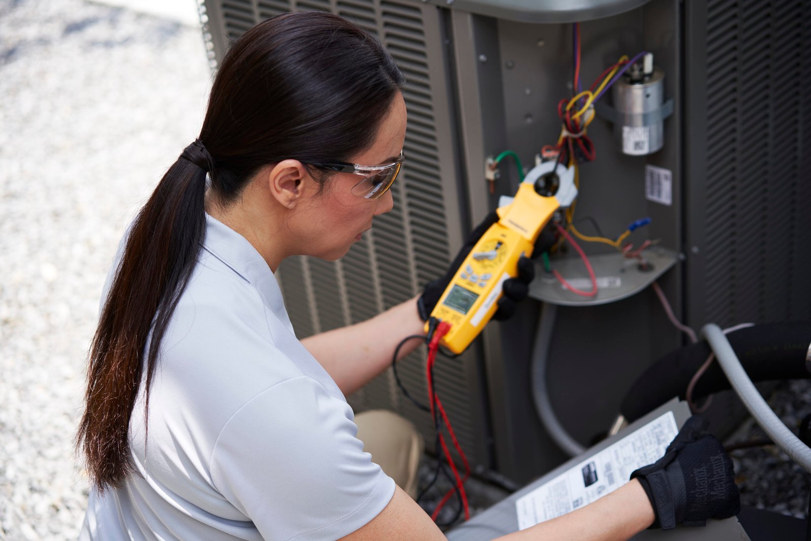 Technician checking an outdoor AC unit during an AC repair visit